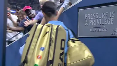 Novak Djokovic carries a gold bag