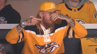 George Kittle chugs a beer at the Predators game
