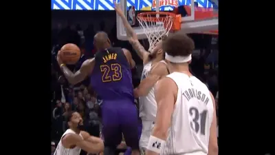 LeBron James dunking over Dereck Lively during a Lakers-Mavs game