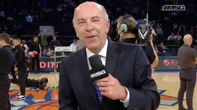 Al Trautwig holds a microphone