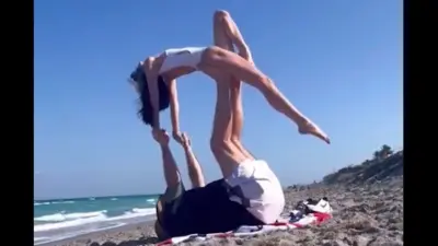 Bill Belichick and his girlfriend do yoga on the beach