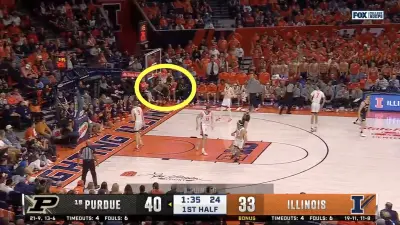 Myles Colvin hanging on the rim after a dunk during a Purdue-Illinois game