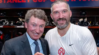 Alex Ovechkin and Wayne Gretzky touching a puck
