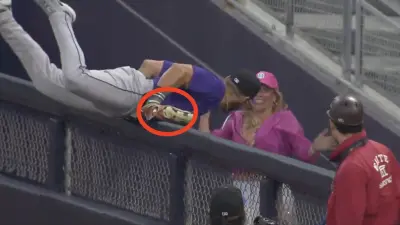 Rockies outfielder Nick Martini making a catch over the right-field fence