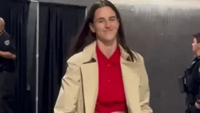 Caitlin Clark in a red shirt and coat