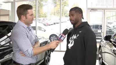 Browns rookie Shedeur Sanders getting interviewed at a car dealership